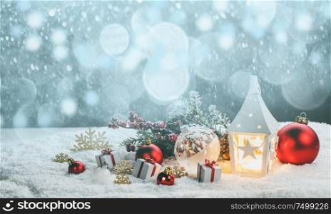 Christmas holidays card with gifts , balls , and glowing lantern in snow. Christmas decor in snow