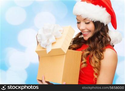 christmas, holidays, celebration and people concept - smiling woman in red dress with small gift box over blue lights background