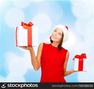 christmas, holidays, celebration and people concept - smiling woman in red dress with gift box over blue lights background