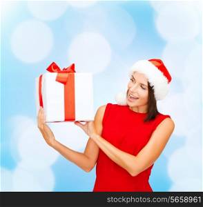 christmas, holidays, celebration and people concept - smiling woman in red dress with gift box over blue lights background