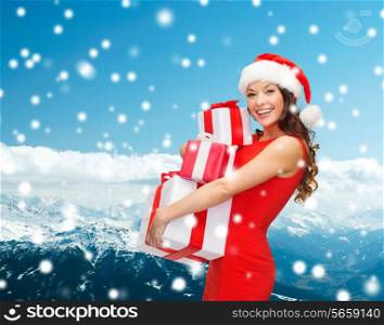 christmas, holidays, celebration and people concept - smiling woman in red dress with gift boxes over blue snowy background
