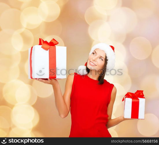 christmas, holidays, celebration and people concept - smiling woman in red dress with gift box over beige lights background