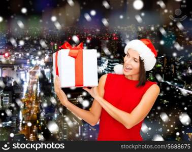 christmas, holidays, celebration and people concept - smiling woman in red dress with gift box over background