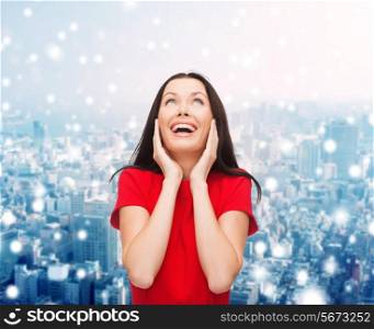 christmas, holidays, celebration and people concept - smiling woman in red dress over snowy city background