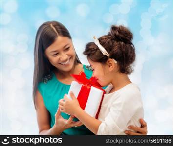 christmas, holidays, celebration, family and people concept - happy mother and girl with gift box over blue lights background