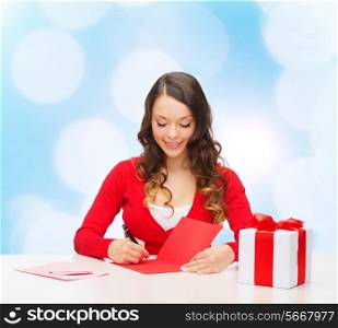 christmas, holidays, celebration, greeting and people concept - smiling woman with gift box writing letter or sending post card over blue lights background