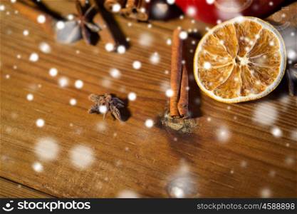 christmas, holidays, cooking and spice concept - close up of cinnamon, anise and dried orange on wooden board. cinnamon, anise and dried orange on wooden board