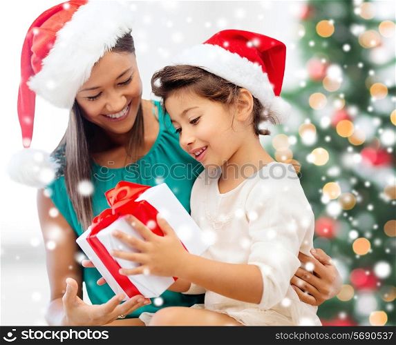 christmas, holidays, family and people concept - happy mother and child girl with gift box at home