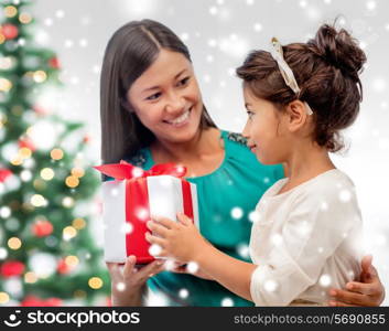 christmas, holidays, family and people concept - happy mother and child girl with gift box at home