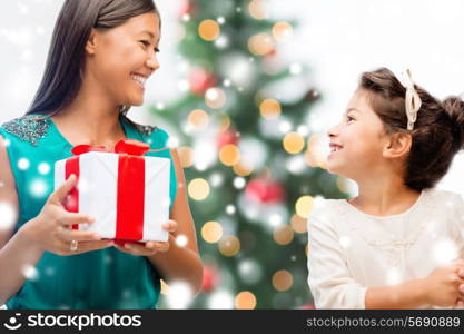 christmas, holidays, family and people concept - happy mother and child girl with gift box at home