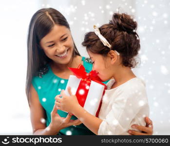 christmas, holidays, family and people concept - happy mother and child girl with gift box at home