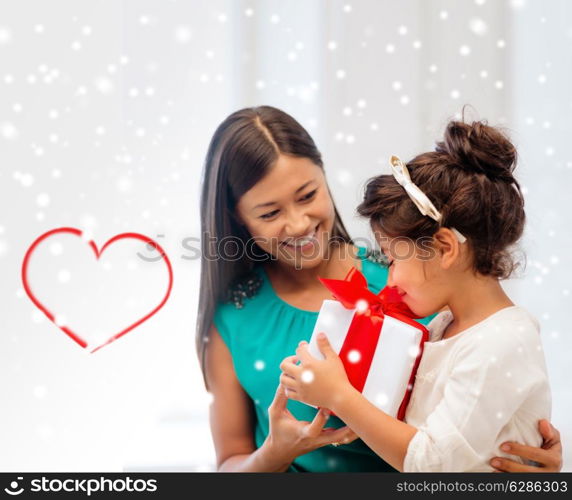 christmas, holidays, family and people concept - happy mother and child girl with gift box at home