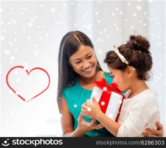 christmas, holidays, family and people concept - happy mother and child girl with gift box at home