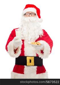 christmas, holidays, food, drink and people concept - man in costume of santa claus with glass of milk and cookies
