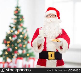 christmas, holidays, food, drink and people concept - man in costume of santa claus with glass of milk and cookies over living room with tree