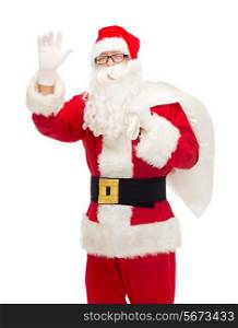 christmas, holidays, gesture and people concept - man in costume of santa claus with bag waving hand