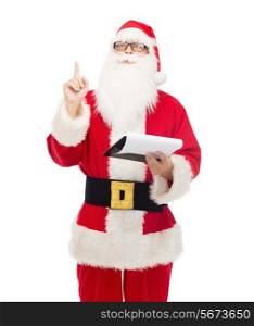 christmas, holidays, gesture and people concept - man in costume of santa claus with notepad pointing finger up
