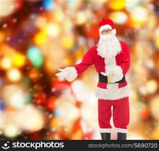 christmas, holidays, gesture and people concept - man in costume of santa claus over red lights background