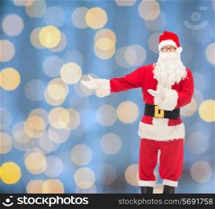 christmas, holidays, gesture and people concept - man in costume of santa claus over blue lights background