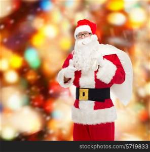 christmas, holidays, gesture and people concept - man in costume of santa claus with bag showing thumbs up over red lights background