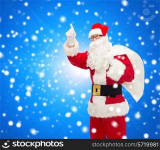 christmas, holidays, gesture and people concept - man in costume of santa claus with bag pointing finger up over blue snowy background