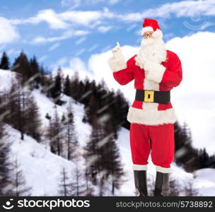 christmas, holidays, gesture and people concept - man in costume of santa claus pointing fingers over snowy mountains background
