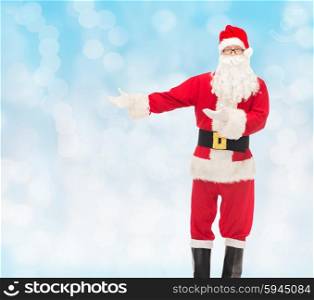 christmas, holidays, gesture and people concept - man in costume of santa claus over blue lights background
