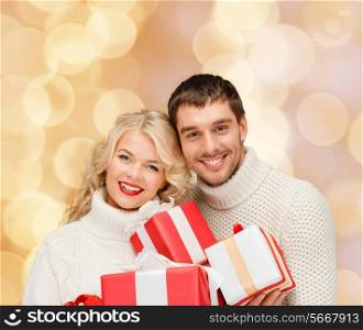 christmas, holidays, happiness and people concept - smiling man and woman with presents over beige lights background