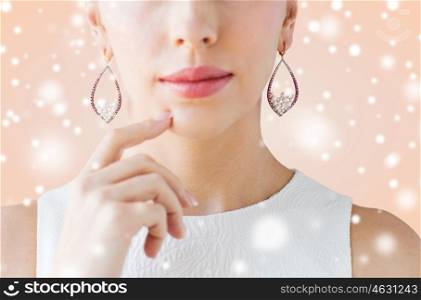 christmas, holidays, jewelry, people and luxury concept - close up of beautiful woman face with pearl earrings over beige background