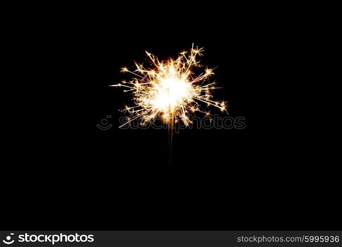 christmas, holidays, new year party and pyrotechnics concept - sparkler or bengal light burning over black background