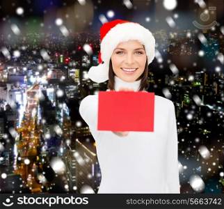 christmas, holidays, people, advertisement and sale concept - happy woman in santa helper hat with blank red card over snowy night city background