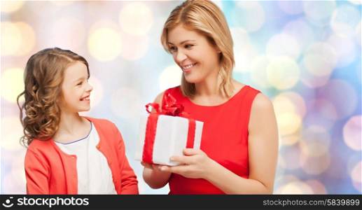 christmas, holidays, people and family concept - smiling mother and daughter with gift box