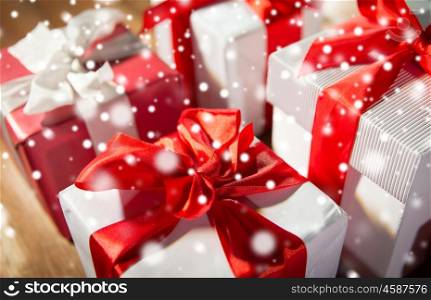 christmas, holidays, presents, new year and celebration concept - close up of gift boxes and red balls on wooden floor