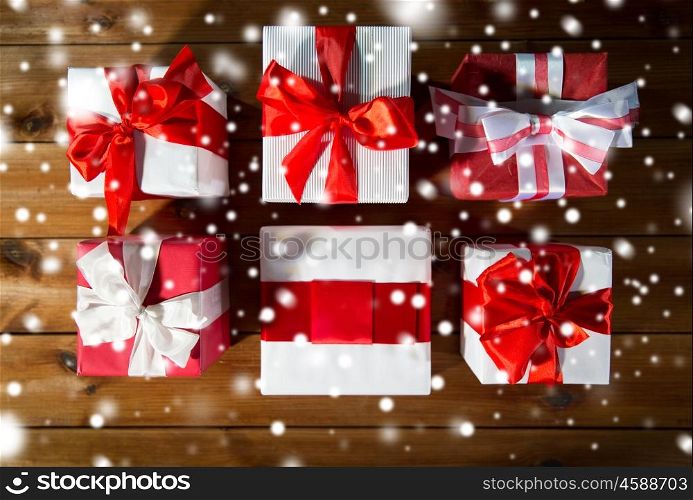 christmas, holidays, presents, new year and celebration concept - close up of gift boxes and red balls on wooden floor from top