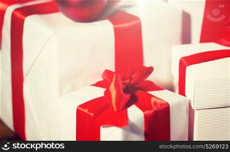 christmas, holidays, presents, new year and celebration concept - close up of gift boxes and red balls on wooden floor. close up of gift boxes and red christmas balls