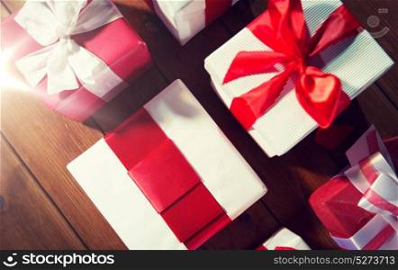 christmas, holidays, presents, new year and celebration concept - close up of gift boxes and red balls on wooden floor from top. close up of gift boxes on wooden floor from top