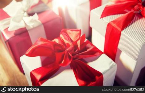 christmas, holidays, presents, new year and celebration concept - close up of gift boxes and red balls on wooden floor. close up of gift boxes on wooden floor