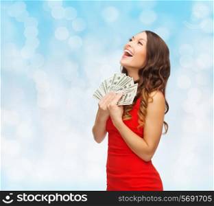 christmas, holidays, sale, banking and people concept - smiling woman in red dress with us dollar money over blue lights background