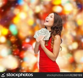 christmas, holidays, sale, banking and people concept - smiling woman in red dress with us dollar money over red lights background
