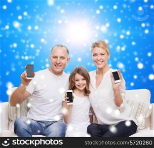 christmas, holidays, technology, advertisement and people concept - smiling family with smartphones over blue snowy background