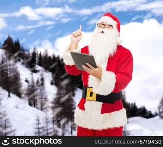 christmas, holidays, technology and people concept - man in costume of santa claus with tablet pc computer pointing finger up over snowy mountains background