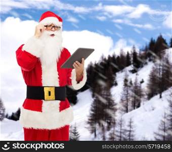 christmas, holidays, technology and people concept - man in costume of santa claus with tablet pc computer over snowy mountains background