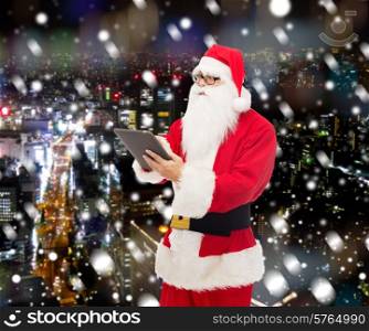 christmas, holidays, technology and people concept - man in costume of santa claus with tablet pc computer over snowy night city background