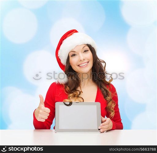 christmas, holidays, technology and people concept - smiling woman in santa helper hat with tablet pc computer showing thumbs up over blue lights background