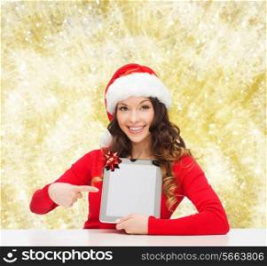 christmas, holidays, technology and people concept - smiling woman in santa helper hat with tablet pc computer over yellow lights background