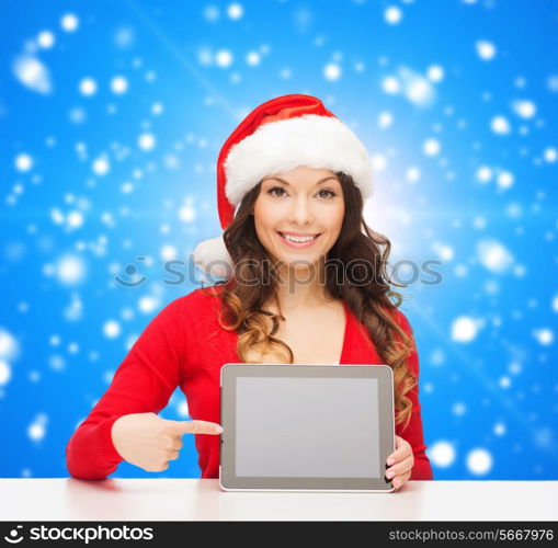 christmas, holidays, technology and people concept - smiling woman in santa helper hat with tablet pc computer over blue snowing background