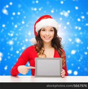 christmas, holidays, technology and people concept - smiling woman in santa helper hat with tablet pc computer over blue snowing background