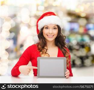 christmas, holidays, technology and people concept - smiling woman in santa helper hat with tablet pc computer over lights background