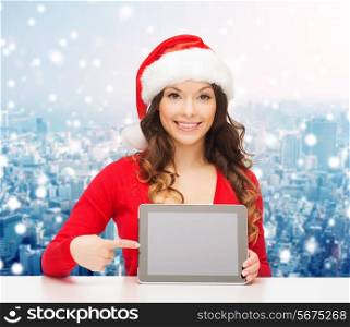 christmas, holidays, technology and people concept - smiling woman in santa helper hat with tablet pc computer over snowy city background