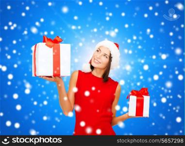 christmas, holidays, valentine&#39;s day, celebration and people concept - smiling woman in red dress with gift box over blue snowy background